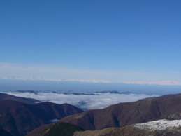 Sotto di noi  le nuvole coprono le depressioni del terreno e laggiù la cerchia alpina splende nel cielo azzurro.